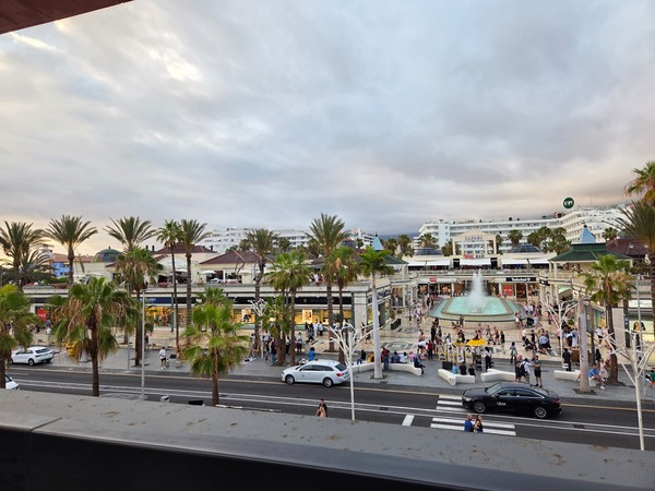 Panoramablick vom Rooftop des Hard Rock Cafe Tenerife über das Safari Center in Playa de las Américas mit Springbrunnen und vielen Besuchern.