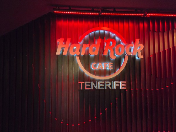 Leuchtendes Hard Rock Cafe Tenerife Logo an der Innenwand in roter Bühnenbeleuchtung.