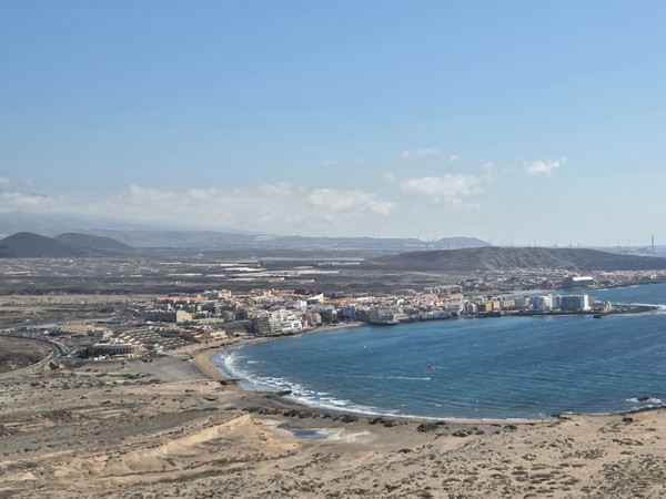 Panoramablick von Montaña Roja über die Bucht von El Médano mit Promenade und Hotels.