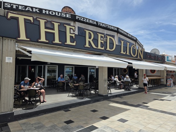 Außenterrasse des Red Lion Pubs an der Playa Fañabé mit Gästen